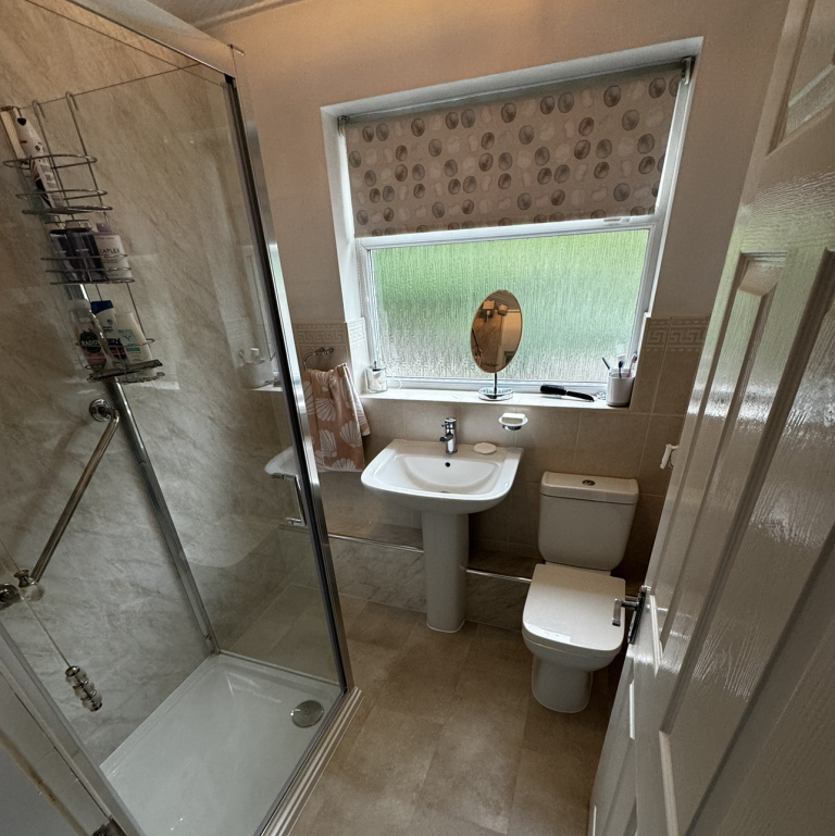 Tiled bathroom with sink shower and toilet