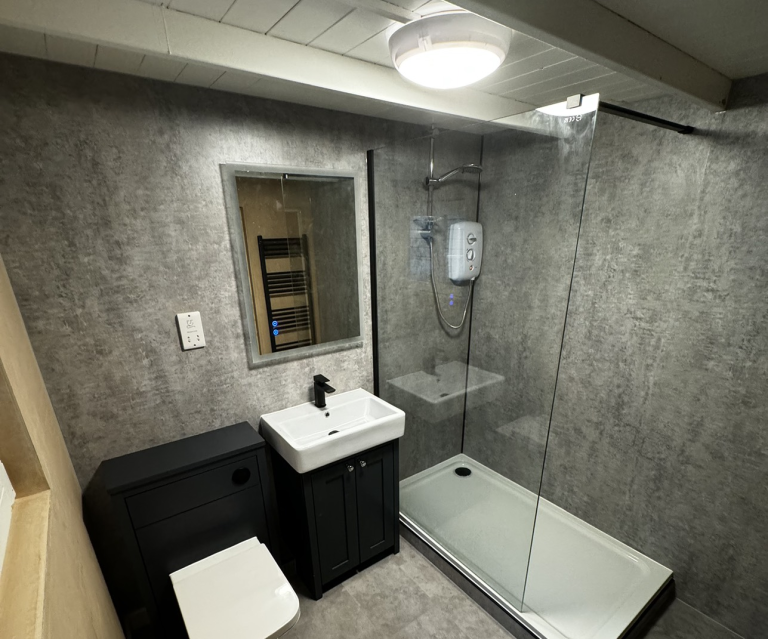 Well lit bathroom with dark cabinets and modern fixtures