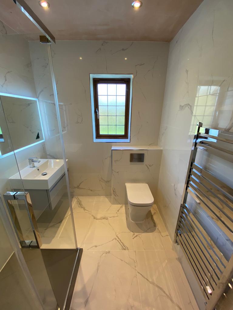 Clean Tailed Bathroom With Modern Toilet Sink and Shower